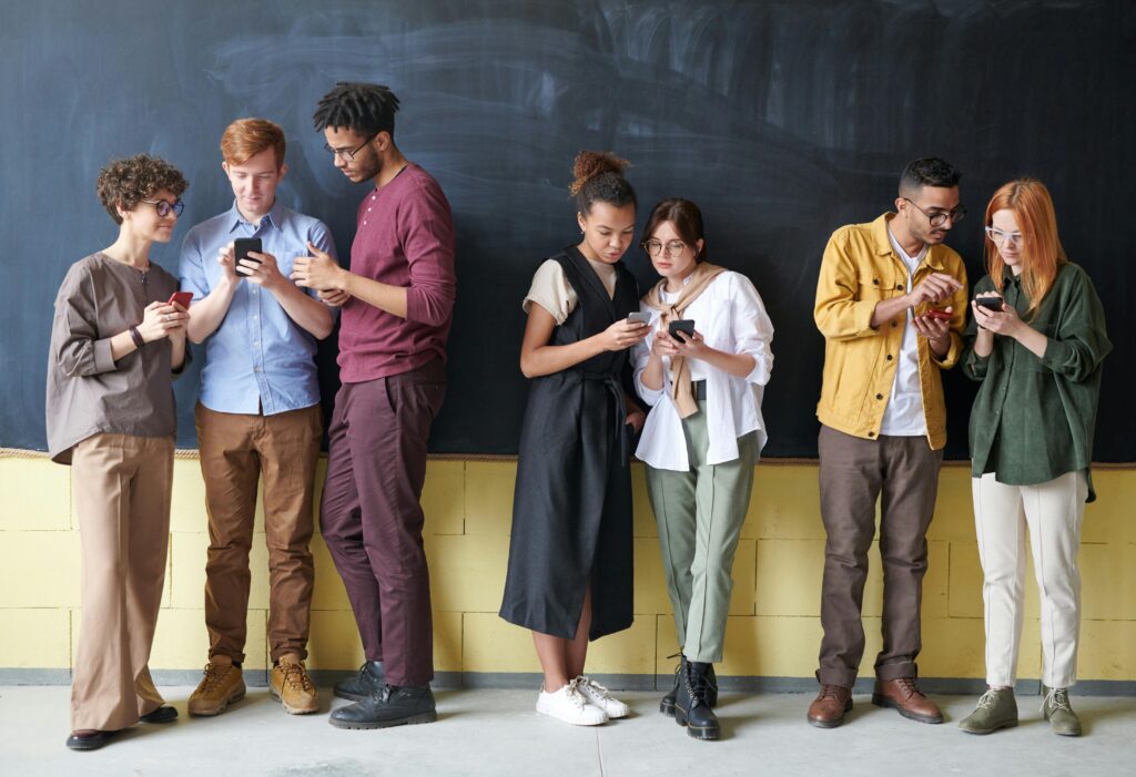 Young Ghanaians using smartphones, reflecting growing adoption of digital security tools.