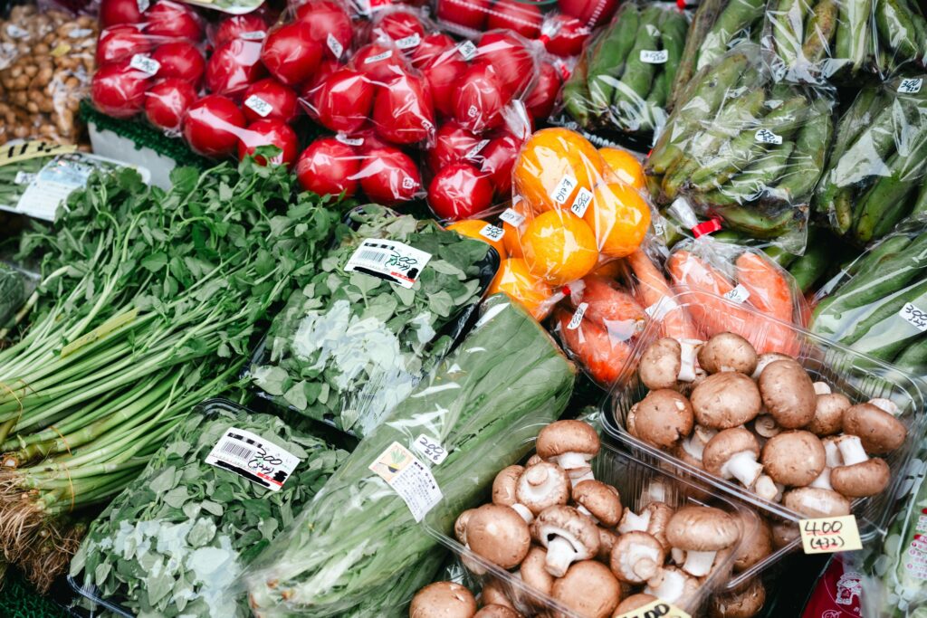Fresh vegetables being sorted, cut, and packaged for supermarkets.