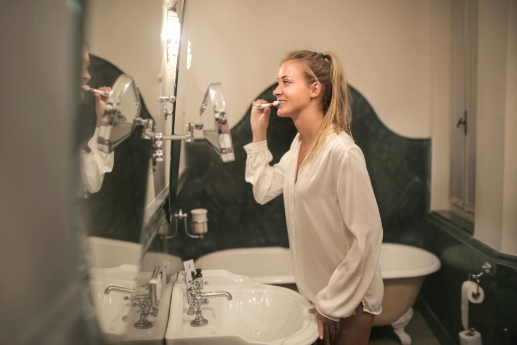 Close-up of a person brushing teeth with a soft-bristled toothbrush and fluoride toothpaste as part of daily oral hygiene routine.