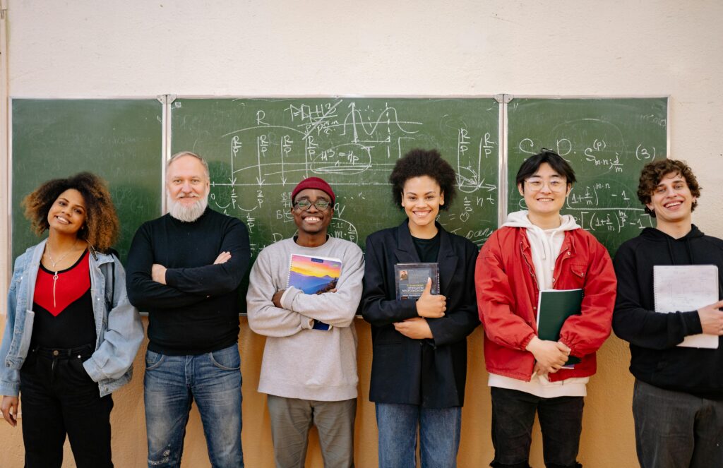 Diverse group of international students in a virtual leadership training session, smiling and engaging with mentors.